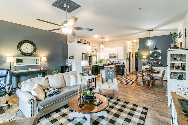 living room featuring wood-type flooring and ceiling fan