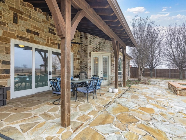 view of patio / terrace with outdoor dining space, fence, and french doors