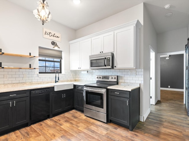 kitchen with stainless steel appliances, dark cabinetry, and a sink