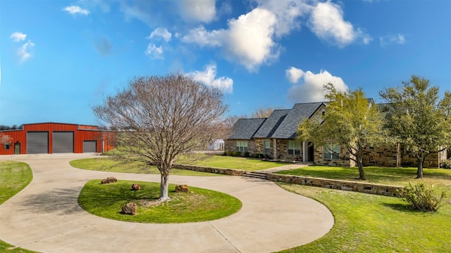 view of property's community featuring a lawn and an outdoor structure