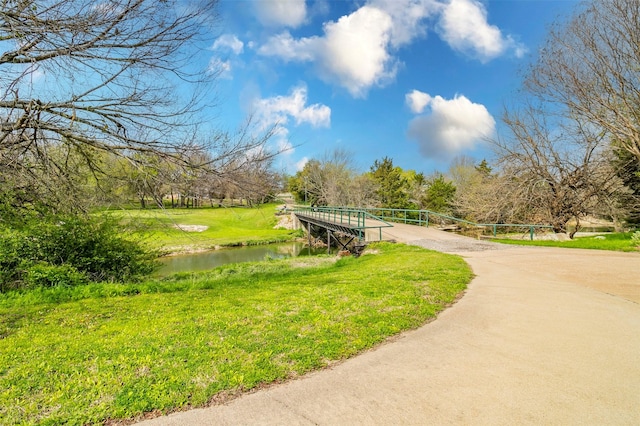 surrounding community featuring a water view and a lawn