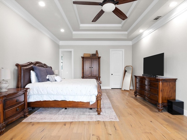 bedroom with a tray ceiling, crown molding, recessed lighting, visible vents, and light wood-style flooring