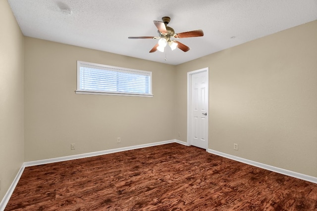 unfurnished room with dark hardwood / wood-style flooring, ceiling fan, and a textured ceiling