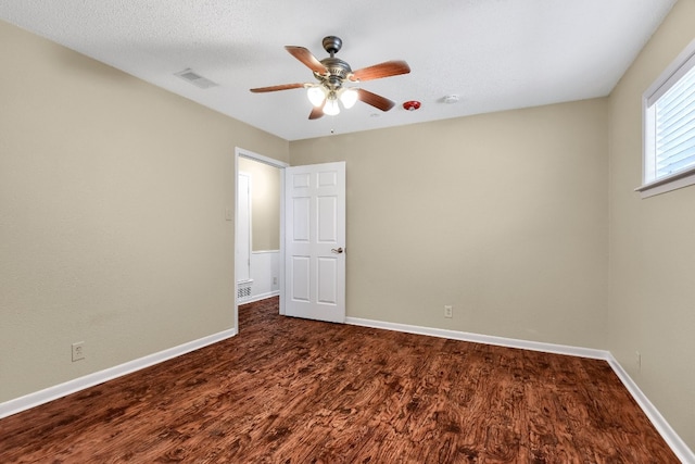 unfurnished room with dark hardwood / wood-style flooring, ceiling fan, and a textured ceiling