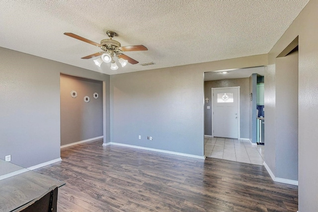 spare room with ceiling fan, wood-type flooring, and a textured ceiling