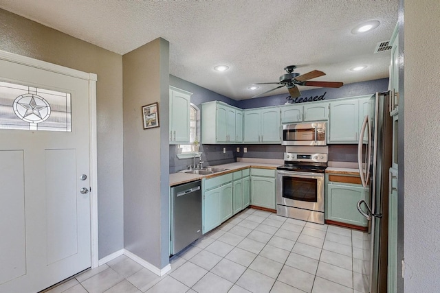 kitchen featuring ceiling fan, a healthy amount of sunlight, stainless steel appliances, and sink