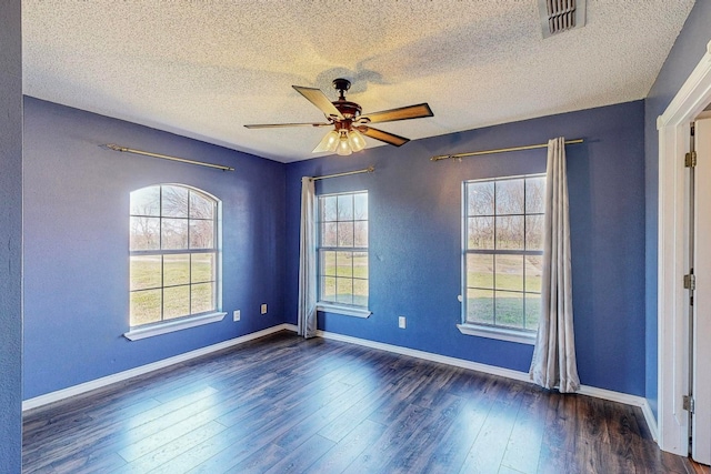 unfurnished room featuring dark wood-type flooring, ceiling fan, and a textured ceiling