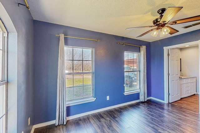 unfurnished bedroom with ceiling fan, dark hardwood / wood-style floors, and a textured ceiling