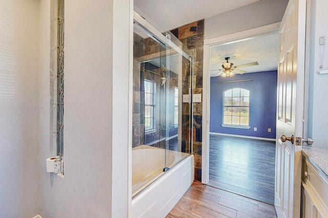 bathroom with wood-type flooring, a textured ceiling, ceiling fan, and shower / bath combination with glass door