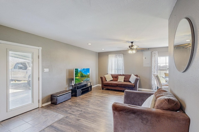 living room with light hardwood / wood-style flooring and ceiling fan