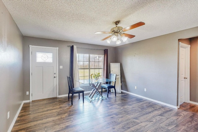 unfurnished room featuring dark wood-type flooring, a textured ceiling, and ceiling fan