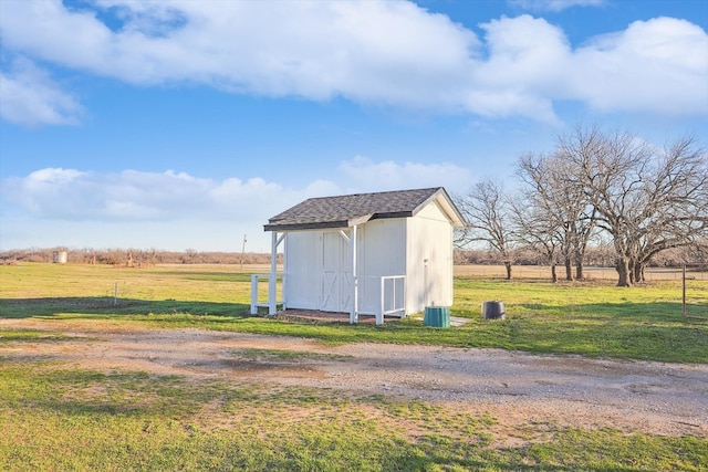 view of shed / structure featuring a rural view and a yard