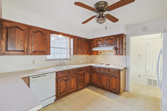 kitchen featuring ceiling fan, stainless steel fridge, light tile flooring, sink, and dishwasher