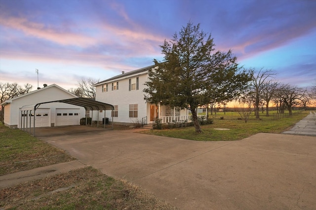 view of front of property with a carport, a garage, and a yard