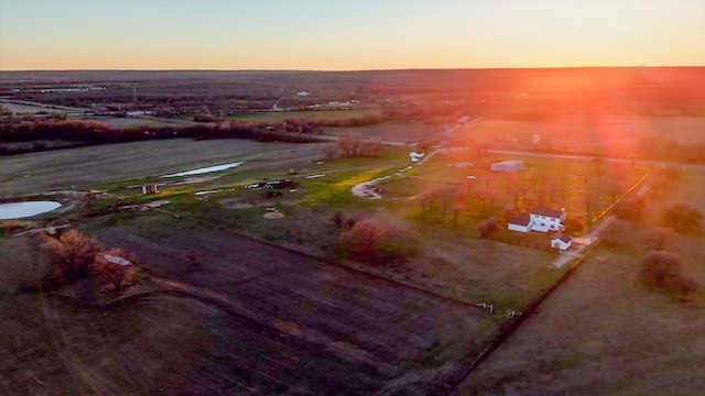 aerial view at dusk featuring a water view