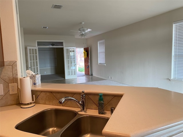 kitchen featuring ceiling fan, backsplash, sink, and french doors