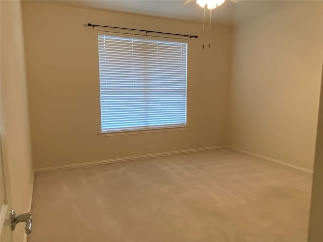 carpeted spare room with ceiling fan