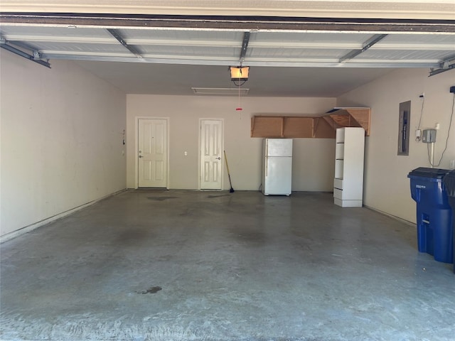 garage featuring white refrigerator and a garage door opener