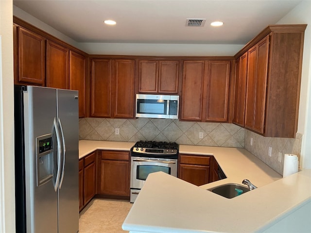 kitchen featuring tasteful backsplash, stainless steel appliances, light tile floors, and sink