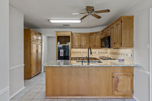 kitchen featuring light tile patterned flooring, kitchen peninsula, ceiling fan, black appliances, and decorative backsplash