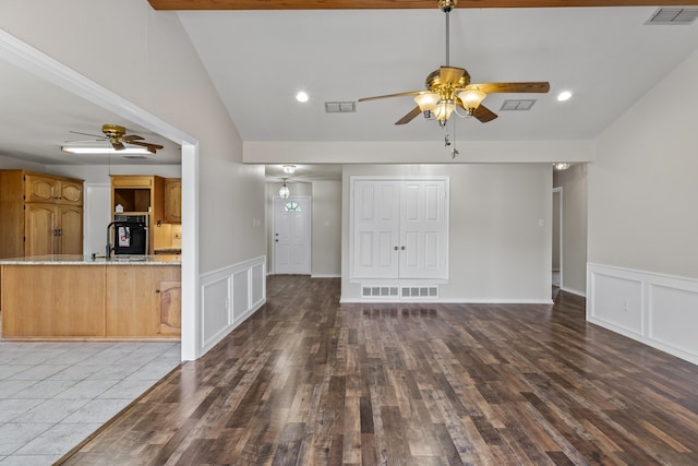 unfurnished living room with sink, tile patterned flooring, beam ceiling, high vaulted ceiling, and ceiling fan