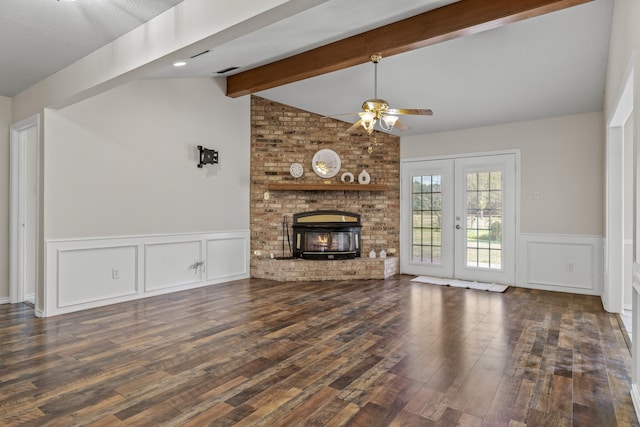 unfurnished living room featuring a fireplace, ceiling fan, vaulted ceiling with beams, dark hardwood / wood-style flooring, and french doors