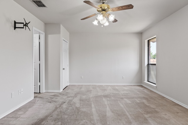 carpeted spare room featuring ceiling fan