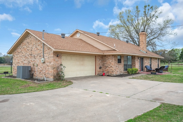 ranch-style home with a garage, central air condition unit, and a front lawn