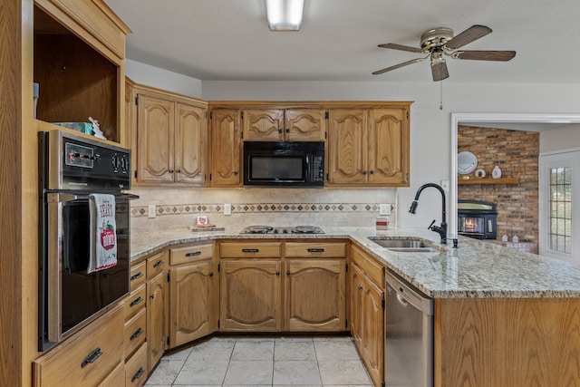 kitchen with tasteful backsplash, light stone counters, appliances with stainless steel finishes, and sink