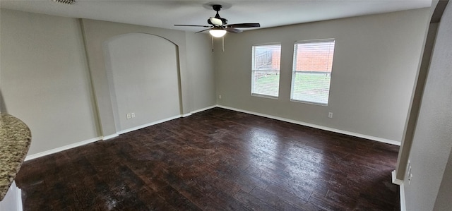 empty room featuring ceiling fan and dark wood-type flooring