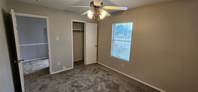 unfurnished bedroom featuring ceiling fan, a closet, and dark carpet