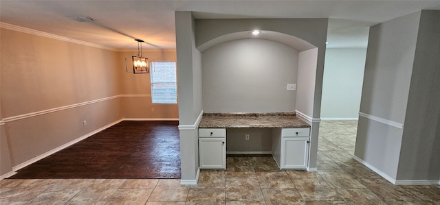 empty room featuring ornamental molding, a chandelier, and light tile floors