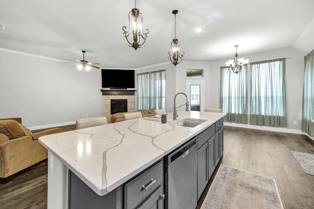 kitchen with stainless steel dishwasher, an island with sink, light stone countertops, and dark hardwood / wood-style floors