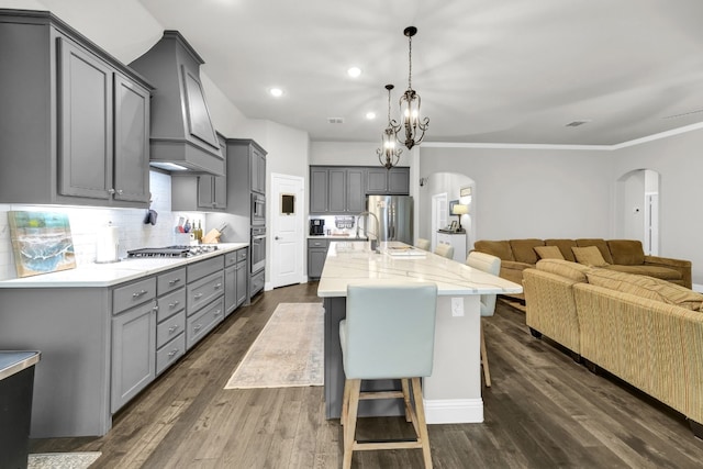 kitchen with dark wood-type flooring, a center island with sink, and gray cabinets