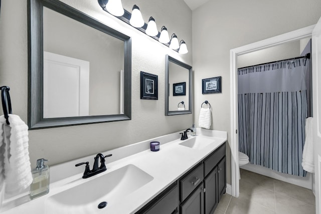 bathroom with toilet, dual bowl vanity, and tile floors