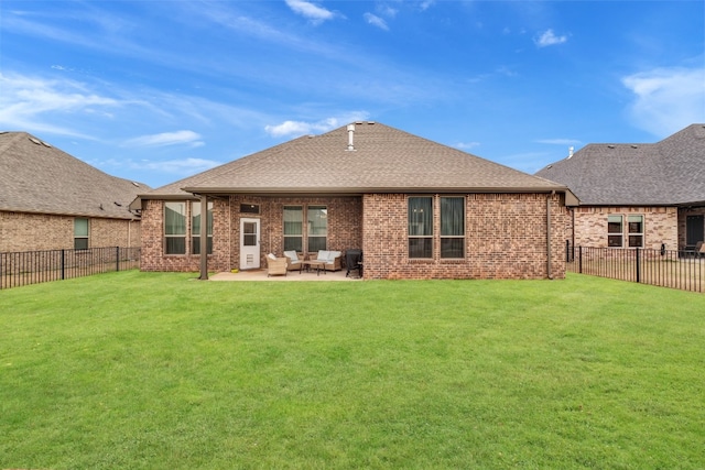 rear view of house with a lawn and a patio