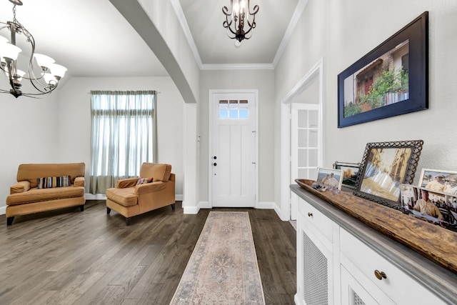 entrance foyer featuring a notable chandelier, plenty of natural light, crown molding, and dark hardwood / wood-style flooring