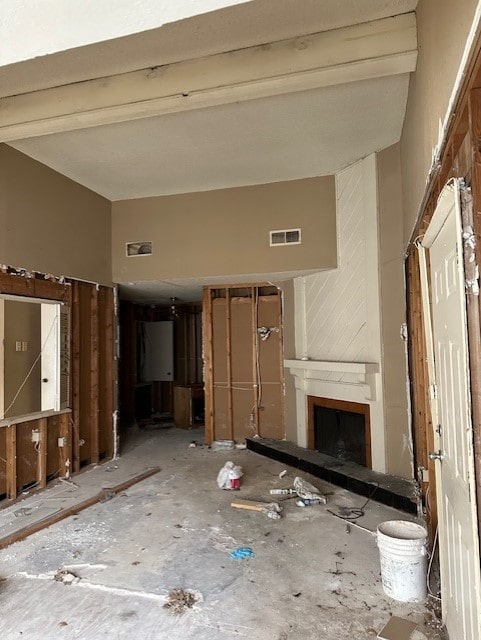 misc room with a towering ceiling, water heater, and beamed ceiling