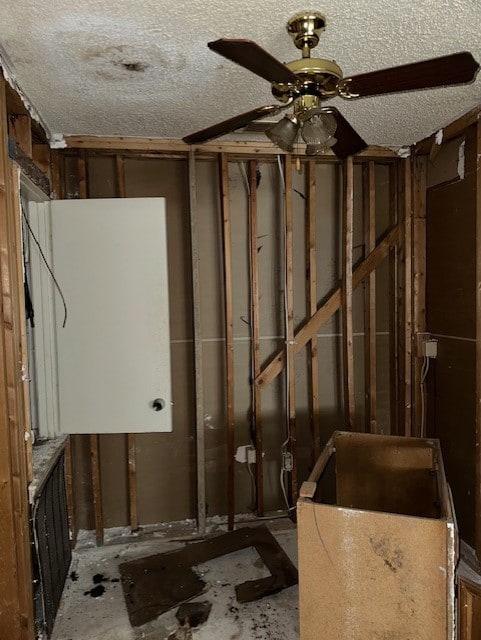 basement with a textured ceiling and ceiling fan