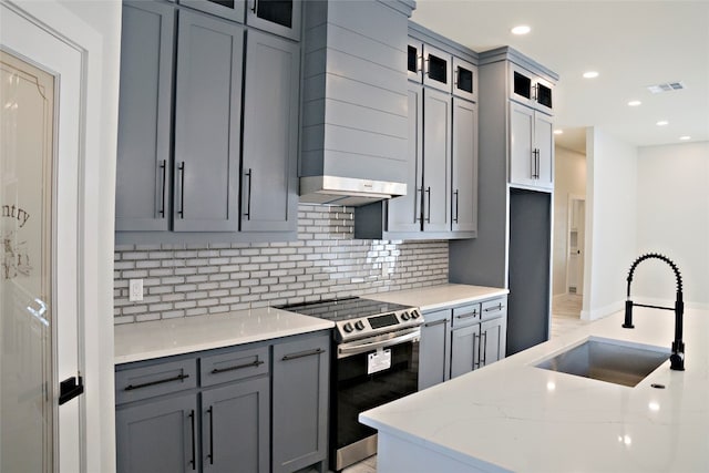 kitchen featuring sink, gray cabinetry, light stone counters, tasteful backsplash, and stainless steel electric range oven