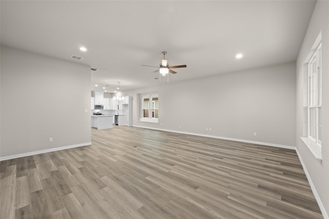 unfurnished living room featuring light hardwood / wood-style flooring and ceiling fan