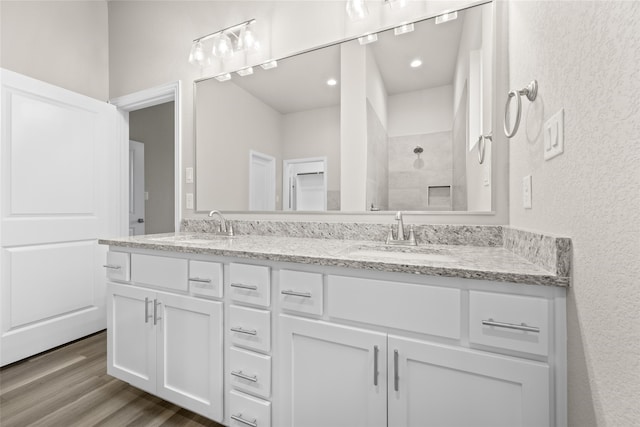 bathroom featuring walk in shower, vanity, and wood-type flooring