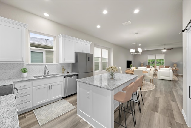 kitchen featuring a healthy amount of sunlight, white cabinetry, sink, and stainless steel appliances