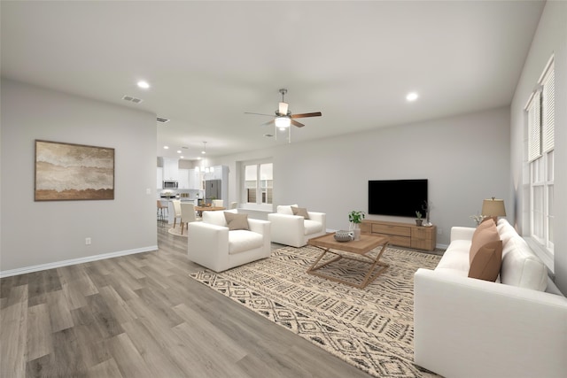 living room featuring light hardwood / wood-style floors and ceiling fan