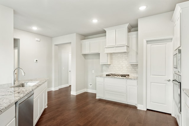 kitchen with white cabinets, light stone countertops, dark hardwood / wood-style floors, a center island with sink, and tasteful backsplash