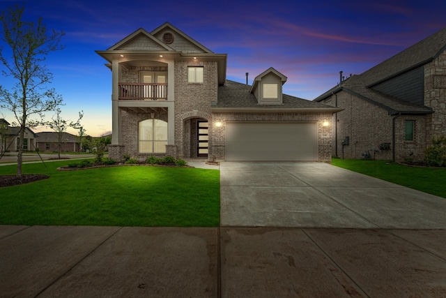 view of front of house featuring a garage, a balcony, and a lawn