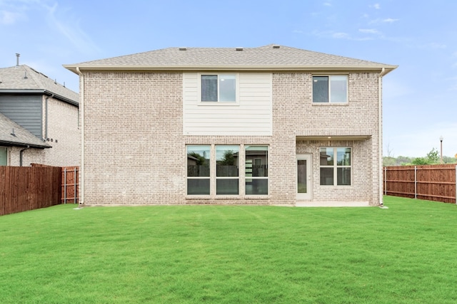 rear view of property featuring a lawn