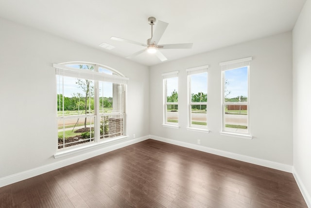 empty room featuring ceiling fan, a healthy amount of sunlight, and dark hardwood / wood-style floors