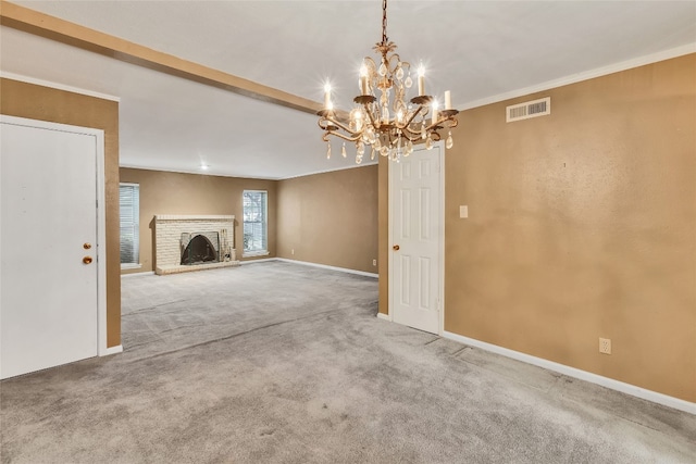 unfurnished living room with an inviting chandelier, ornamental molding, light colored carpet, and a brick fireplace