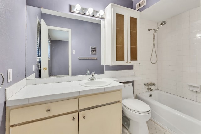 full bathroom with toilet, tile flooring, tiled shower / bath combo, and vanity